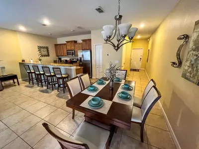 a dining room and kitchen with a table and chairs at Orlando Area Vacation Rental with private pool in Kissimmee