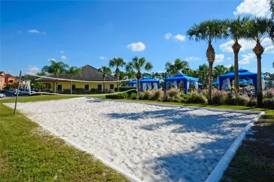 a large white beach with palm trees and a house at Orlando Area Vacation Rental with private pool in Kissimmee