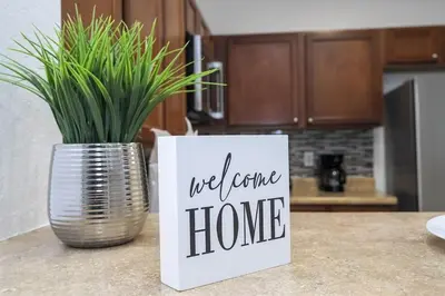 a not centre home sign on a counter with a vase at A Magical condo close to Disney CSS1 in Kissimmee