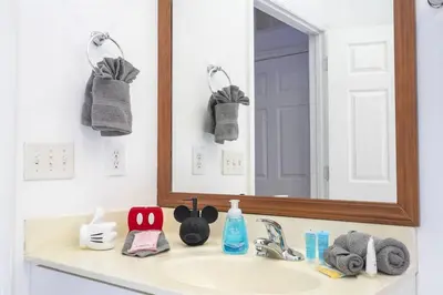 a bathroom sink with a mirror and towels on it at A Magical condo close to Disney CSS1 in Kissimmee