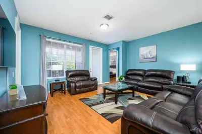 a living room with leather furniture and blue walls at Luxury Lakeview, Vista Cay Orlando 1027 in Orlando