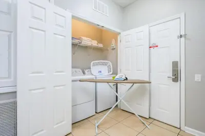 a small kitchen with white cabinets and a table at Epic Universe New Listing Beautiful Vacation Condo - 3018 in Orlando