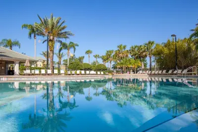 a large swimming pool with palm trees in the background at Beautiful Deluxe Condo, Vista Cay - 3024 in Orlando