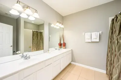 a bathroom with two sinks and a large mirror at New And Gorgeous Townhome, Vista Cay - 4008 in Orlando