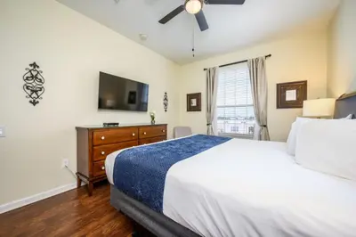 a bedroom with a bed and a flat screen tv at Beautiful Modern Condo, Near The Parks! 3021 in Orlando