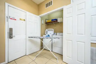 a small kitchen with a table and a door at Beautiful Modern Condo, Near The Parks! 3021 in Orlando