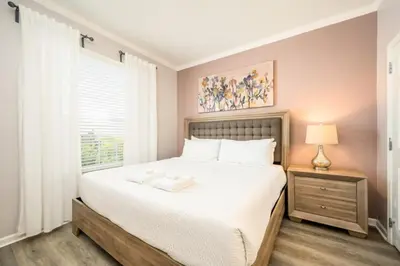 a bedroom with a large white bed and a window at Epic Universe New Deluxe Condo, Vista Cay - 3022 in Orlando