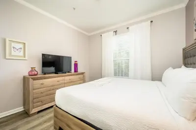 a bedroom with a bed and a flat screen tv at Epic Universe New Deluxe Condo, Vista Cay - 3022 in Orlando