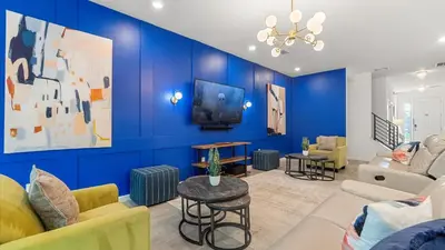 a living room with a blue wall at Upstay Family Home w Pool, Cinema & Games Room in Kissimmee