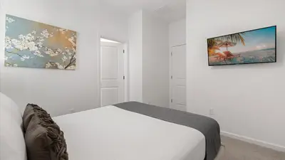 a bedroom with a bed and two pictures on the wall at Upstay Family Home w Pool, Cinema & Games Room in Kissimmee