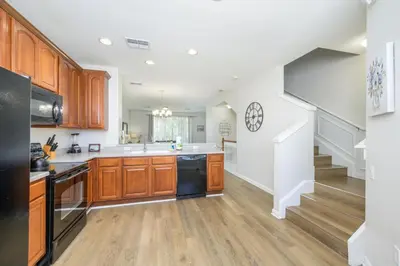 a kitchen with wooden cabinets and a staircase at Epic Universe New Listing, Family Vacation Townhome - 4011 in Orlando
