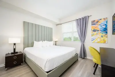 a bedroom with a bed and a desk and a window at Brand New Modern Vista Cay Reserve Condo - 5008 in Orlando