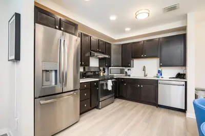a kitchen with stainless steel appliances and wooden cabinets at Brand New Modern Vista Cay Reserve Condo - 5008 in Orlando