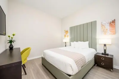 a bedroom with a bed and a desk and a television at Epic Universe Modern Vista Cay Condo - 5005 in Orlando