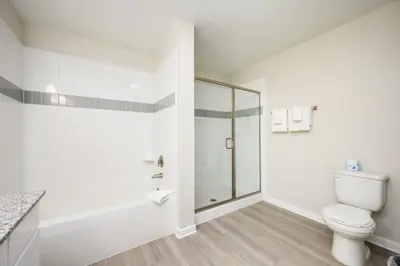 a white bathroom with a shower and a toilet at New Modern Vista Cay Reserve Condo - 6003 in Orlando