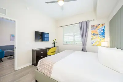 a white bedroom with a bed and a window at Epic Universe New Modern Vista Cay Reserve Condo - 5007 in Orlando