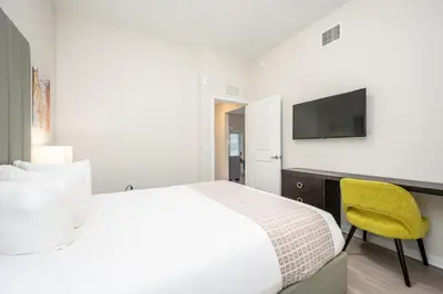 a bedroom with a bed and a desk with a television at Epic Universe New Modern Vista Cay Reserve Condo - 5007 in Orlando