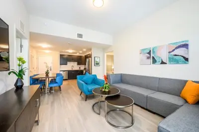 a living room with a gray couch and blue chairs at Epic Universe New Modern Vista Cay Reserve Condo - 5007 in Orlando