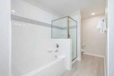 a white bathroom with a shower and a toilet at Epic Universe Brand New Modern Vista Cay Reserve Condo - 6005 in Orlando