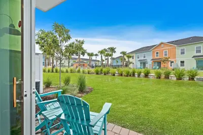 a patio with two chairs and a yard with houses at 3148 Caribbean Soul Drive in Orlando