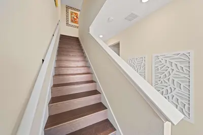 a staircase in a house with white walls and wood floors at 3148 Caribbean Soul Drive in Orlando