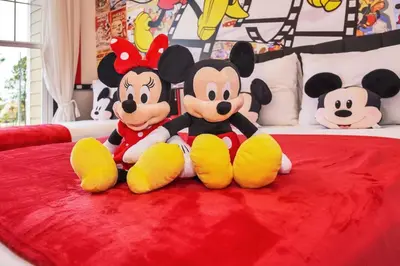 two mickey mouse stuffed animals sitting on a bed at 5 BD 5BA Themed House Near Disney in Orlando