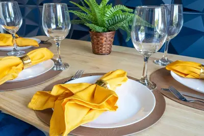 a table with plates and wine glasses and yellow napkins at Cozy apt 2 bedrooms 1 mile Universal Studios in Orlando