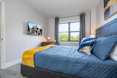 a bedroom with a blue bed and a window at Cozy apt 2 bedrooms 1 mile Universal Studios in Orlando