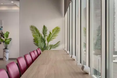 a conference room with a long table and pink chairs at Home2 Suites By Hilton Sanford Orlando North in Sanford