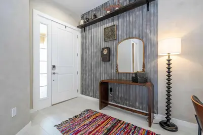 a hallway with a mirror and a lamp and a rug at A Galaxy’s Edge Experience Awaits 5 Min to Disney in Orlando