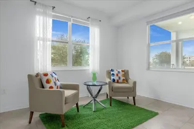 two chairs and a table in a room with windows at 2 Bedrooms 2 Bathrooms Storey Lake Ct in Kissimmee