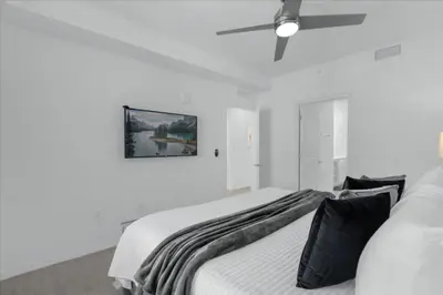 a white bedroom with a bed and a ceiling fan at 2 Bedrooms 2 Bathrooms Storey Lake Ct in Kissimmee