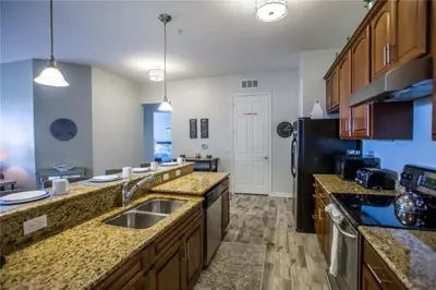 a large kitchen with a sink and a refrigerator at The Epic Boca Penthouse Vista Cay Orlando in Orlando