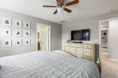 a bedroom with a bed and a flat screen tv at Palms of Paradise! in Kissimmee