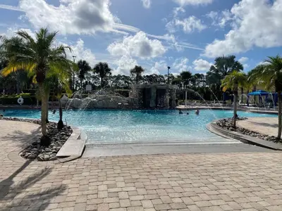 a large swimming pool with palm trees in a park at Palms of Paradise! in Kissimmee