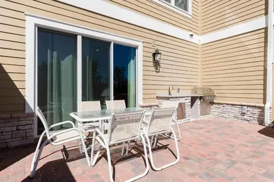 a patio with a table and chairs and a fireplace at Cozy Beautiful 5 Suites close to Disney World in Orlando