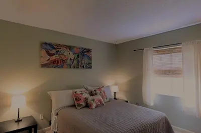 a bedroom with a bed and a painting on the wall at 3 Bed 2 Bath amazing Lakeview , Jacuzzi Bath Tub in Oviedo