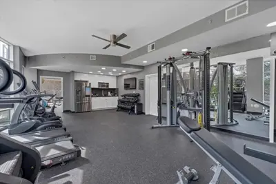 a gym with treadmills and machines and a ceiling fan at Lovely 2Bdrm 2Bath Thorton Park Condo with secure parking in Orlando