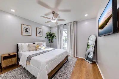 a bedroom with a bed and a ceiling fan at Beautiful home, centrally located to Parks with Pool in Orlando