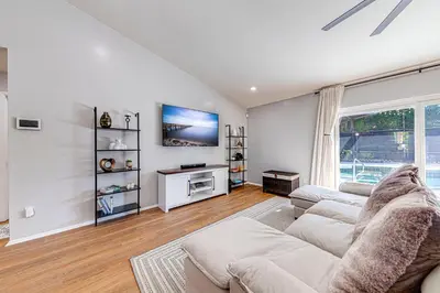 a living room with a couch and a tv at Beautiful home, centrally located to Parks with Pool in Orlando