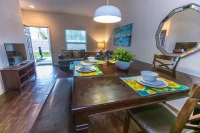 a living room with a wooden table and a dining room at Elegant, Spacious 3bedroom Near Attractions Hot Tub Pool & Gym in Kissimmee