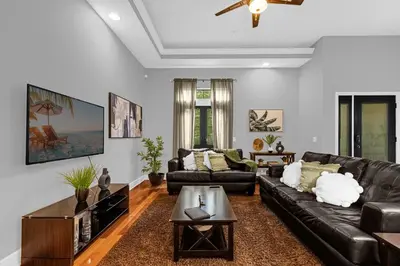 a living room with a leather couch and a coffee table at Enchanted 4BR Family Style Townhome in Disney Area in Orlando