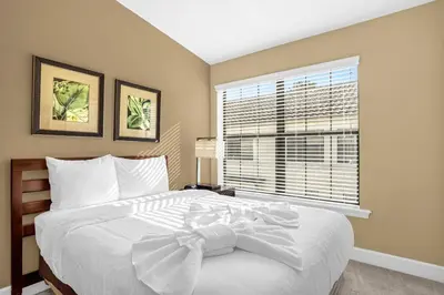 a bedroom with a large white bed with a window at Enchanted 4BR Family Style Townhome in Disney Area in Orlando