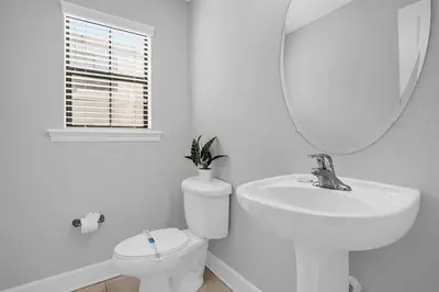 a bathroom with a sink and a toilet and a mirror at Enchanted 4BR Family Style Townhome in Disney Area in Orlando
