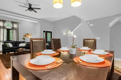 a dining room and living room with a table and chairs at Enchanted 4BR Family Style Townhome in Disney Area in Orlando