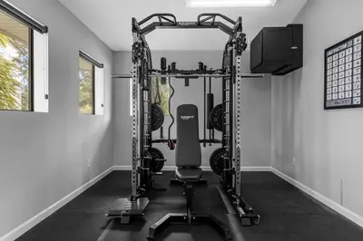 a room with a gym with a bench and equipment at Vibrant 4BR Family Townhome 1 mile from Disney World and Disney Springs in Orlando