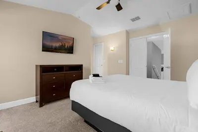 a bedroom with a large white bed and a dresser at Vibrant 4BR Family Townhome 1 mile from Disney World and Disney Springs in Orlando