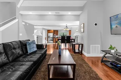 a living room with a black leather couch and a table at Vibrant 4BR Family Townhome 1 mile from Disney World and Disney Springs in Orlando