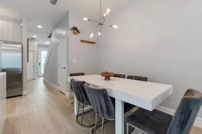 a kitchen and dining room with a white table and chairs at Amazing 4 Bedrooms Next to DisneyPrivate Pool in Orlando
