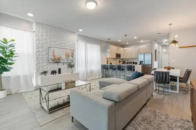 a living room with a couch and a kitchen at Amazing 4 Bedrooms Next to DisneyPrivate Pool in Orlando